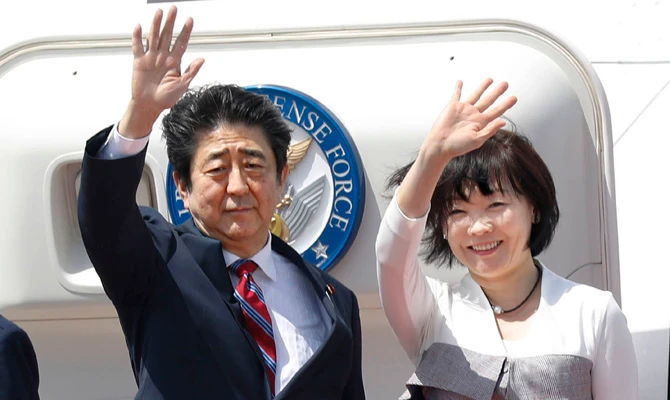 Japanese Prime Minister Shinzo Abe, left, waves with his wife Akie Abe while boarding his plane before departure for the Middle Eastern countries, at Haneda international airport in Tokyo Sunday, April 29, 2018. (Yukie Nishizawa/Kyodo News via AP)