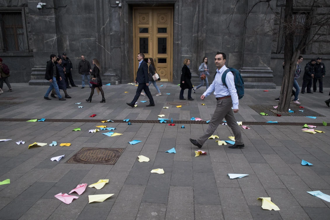 People walk past paper airplanes that were thrown by protesters in front of the building of the Federal Security Service in Lubyanskaya Square in Moscow. (AP)