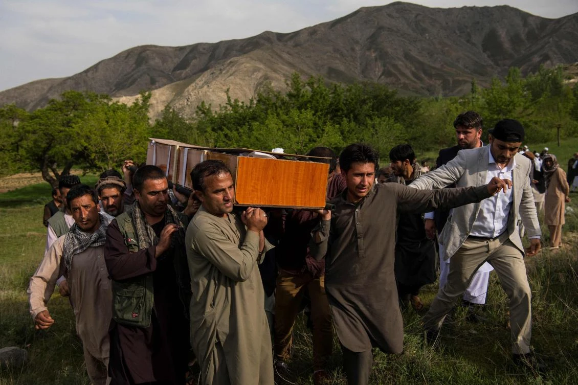 Relatives and friends of AFP Afghanistan chief photographer Shah Marai Faizi carry his coffin before his burial in Gul Dara, Kabul after his death in the second of two bombings that occurred in the Afghan capital. (AFP)