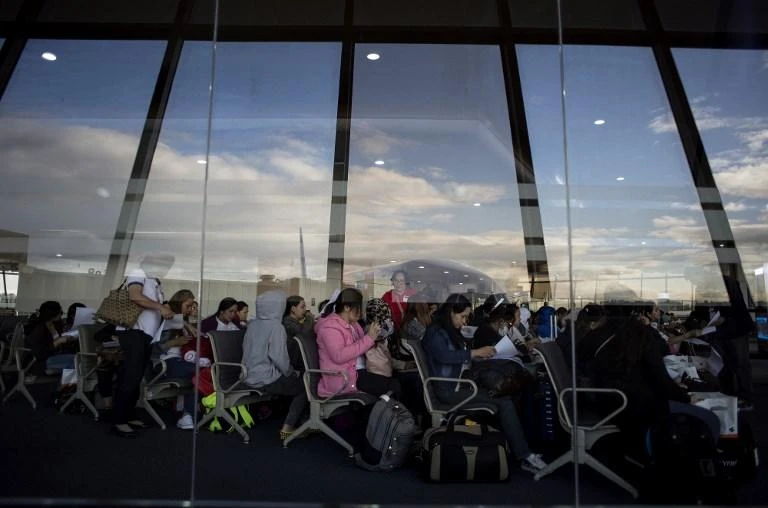 In this file photo taken on February 18, 2018, Filipina workers returning home from Kuwait fill out forms upon their arrival at Manila International Airport. (AFP)