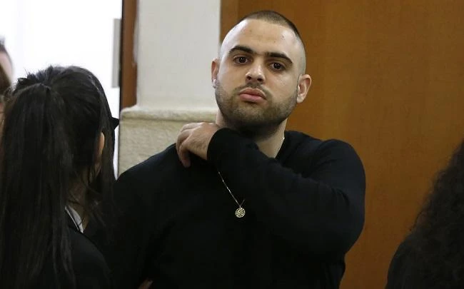 Ben Deri (C), a 24-year-old Israeli policeman accused of killing a Palestinian teenager in 2014 during clashes in Beitunia in the occupied West Bank, is seen at the district court in Jerusalem on April 25, 2018. (AFP)