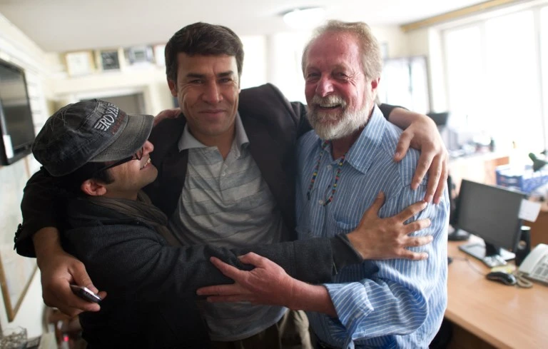In this file photo taken on April 17, 2012 Agence France-Presse (AFP) photographer Shah Marai (C) embraces colleagues Massoud Hossaini (L) and Lawrence Bartlett (R), after Hossain had won the Pulitzer Prize, at the AFP office in Kabul. (AFP)