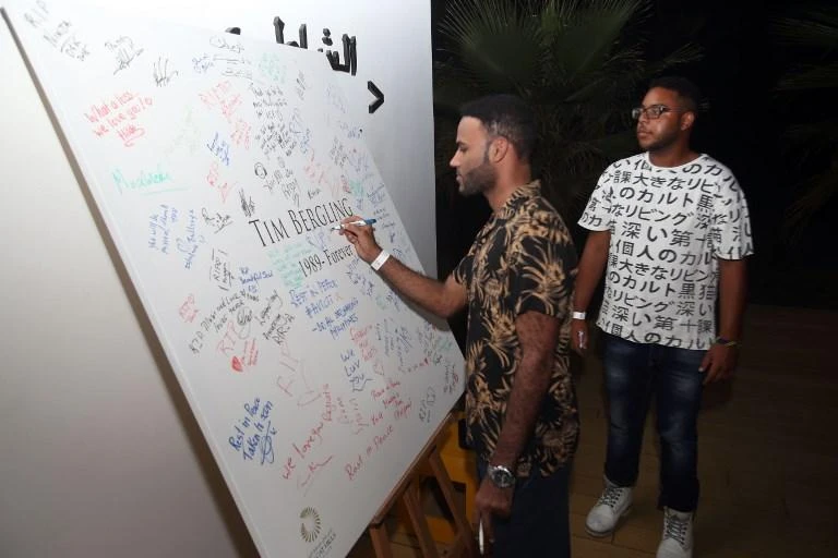 A fan signs a memorial for Swedish DJ Tim Bergling, known as Avicii, during a gathering in his memory in Muscat, oman on April 27. (AFP)