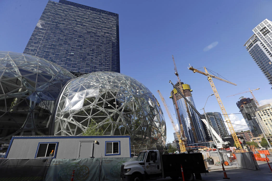 Large spheres take shape in front of an existing Amazon building, behind, as new construction continues across the street in Seattle in this October 2017 photo. Amazon is pausing construction on a new high-rise building in Seattle while it awaits the outcome of a city proposal to tax worker hours. (AP)