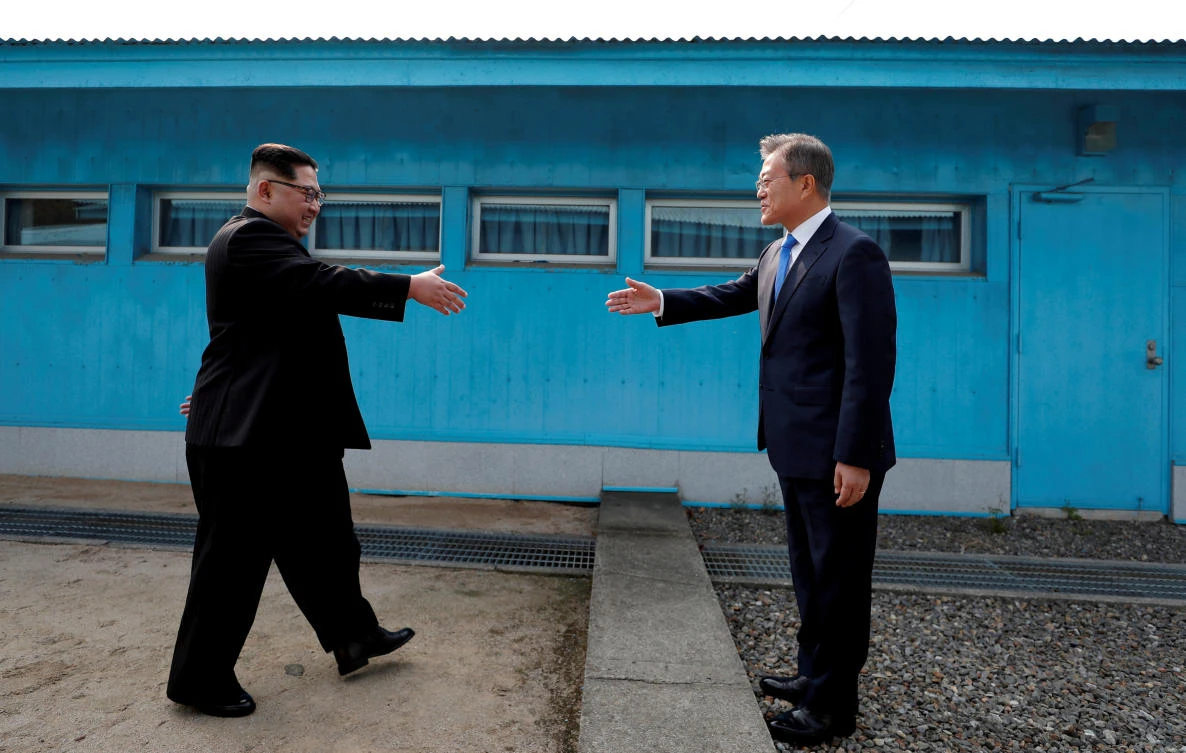 South Korean President Moon Jae-in and North Korean leader Kim Jong Un, left, meet at the demarcation line separating the two Koreas before the start of their historic talks on April 27. (Korea Summit Press Pool via Reuters)
