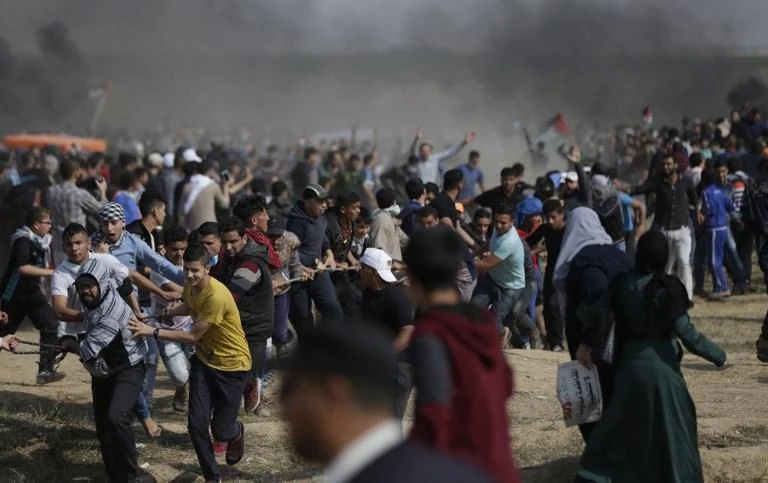 Palestinian demonstrators try to pull down part of the fence on the Israel-Gaza border, east of Gaza City in the central Gaza Strip on April 27. (AFP)