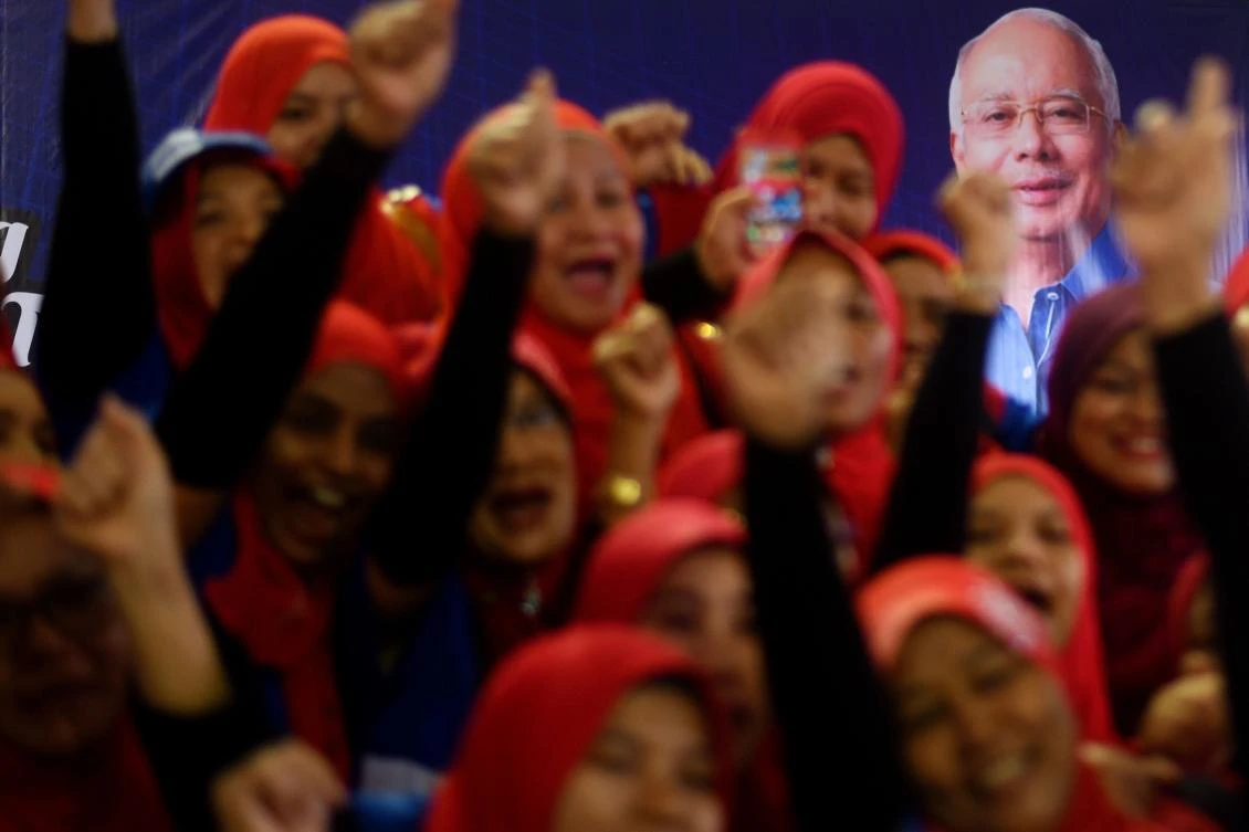 Supporters of Malaysian Prime Minister Najib Razak and the ruling coalition party Barisan Nasional cheer during a campaign event in Kuala Lumpur. Najib faces a tough test at the Wednesday vote due to a corruption scandal surrounding state fund 1MDB and a challenge from veteran ex-leader Mahathir Mohamad. (AFP)
