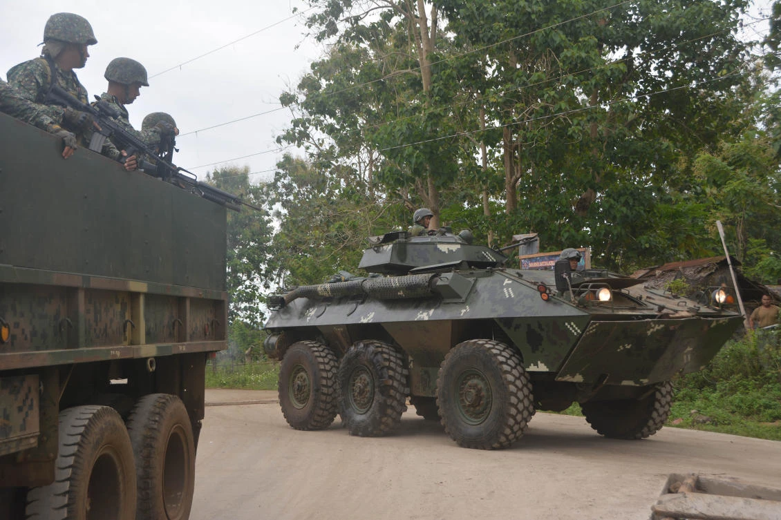 Philippine marines aboard an Amored Personnel Carrier (APC) and a truck guard a highway in Indanan town, Sulu province on the southern island of Mindanao on February 27, 2017, after reports of the beheading of German national Jurgen Kantner by the Abu Sayyaf group. (Nickee Butlangan/ AFP)