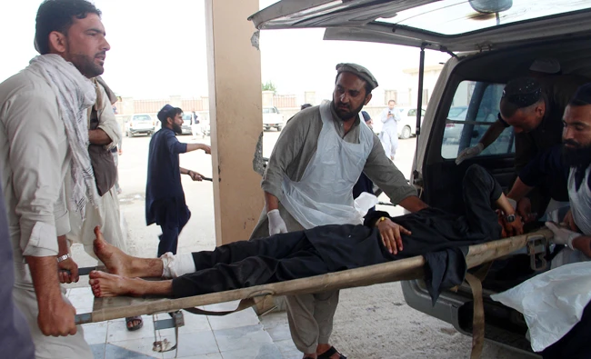An Afghan wounded man lays on a trolley as others rush him to a hospital following blast at a voter registration centre in Khost Province on May 6, 2018. (AFP)