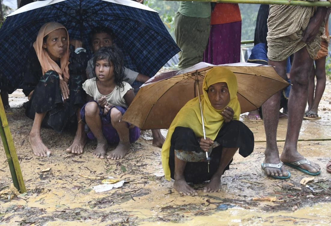 Rohingya refugees protect themselves from rain in Balukhali refugee camp near the Bangladesh town of Gumdhum. (AFP)