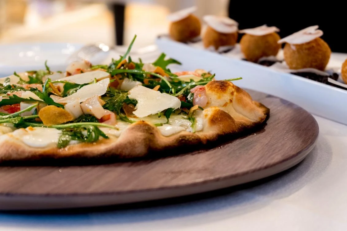 The white pizza — a cheesy, fresh-from-the-oven eight-incher topped with pecorino, mozzarella and crème fraiche, with rocket garnish — is moreish. (Photo supplied)