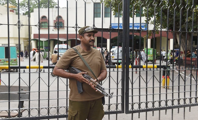 A Pakistani policeman stands guard outside a hospital where country interior minister Ahsan Iqbal shifted after the assassination attempt in Lahore on May 7, 2018. (AFP)