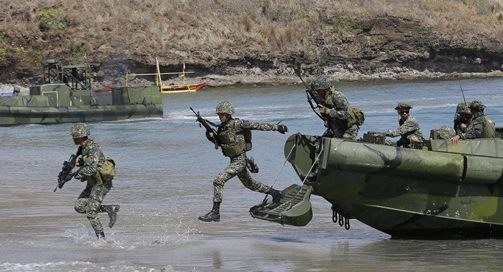 Philippine Marines exit a U.S. landing craft as they assault a target during joint military exercises dubbed Balikatan. About 8,000 combined US and Philippine troops will take part in Balikatan 2018, along with a small contingent from the Australian and Japanese armed forces. (AP Photo)
