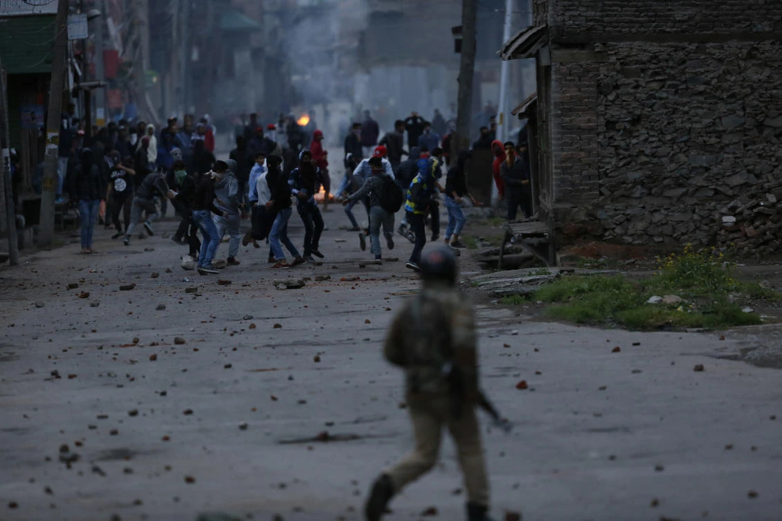 A policeman chases stone throwing protesters in Srinagar of the Indian controlled Kashmir on Monday, May 7. The disputed region shut for a third straight day following the killings of civilians and rebels during weekend gunbattles and anti-India protests. (AP)