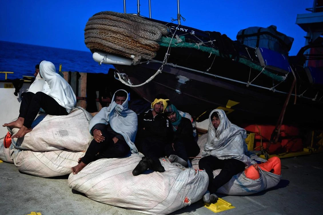 Migrants sit aboard MV Aquarius, a rescue vessel chartered by SOS-Mediterranee and Doctors Without Borders (MSF), at the Mediterranean sea while its bound for Italy on May 9, 2018. (AFP)