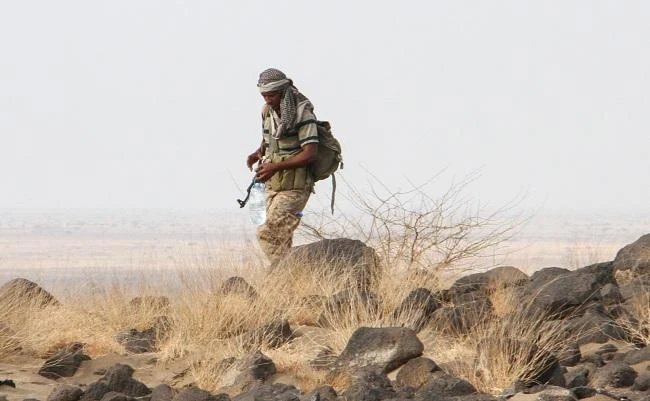 A Yemeni fighter loyal to the Saudi-backed Yemeni president carries a bottle of water during a patrol of a hill-top position northwest of the central city of Taiz, on April 20, 2017. (AFP)