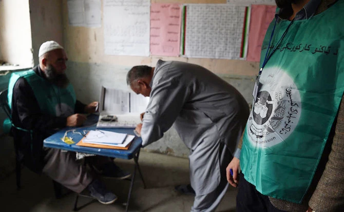 Afghan employees of the Independent Election Commission (IEC) registering a resident at a voter registration center for the upcoming parliamentary and district council elections in Kabul. (AFP)