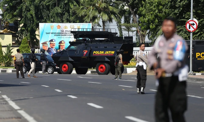 Officers block a road following an attack at the local police headquarters in Surabaya, East Java, Indonesia, on Monday. (AP Photo/Achmad Ibrahim)
