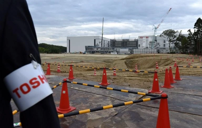 Toshiba in November said it was still waiting for Chinese antitrust authorities to approve the key sale but denied speculation that it was considering reversing course in the deal. Above, construction site at a new Toshiba semiconductor manufacturing plant in Yokkaichi. (AFP)