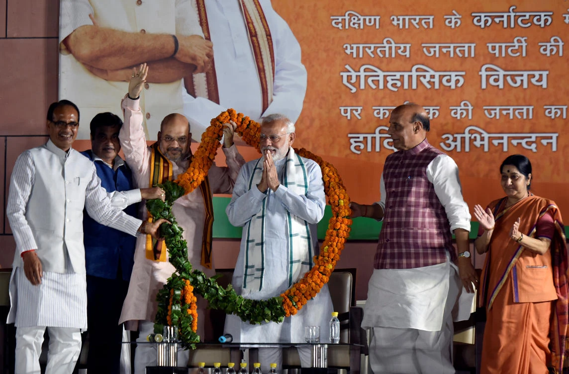 India’s Prime Minister Narendra Modi (C) is presented with a flower garland after the Karnataka state election results, at BJP’s party headquarters in New Delhi. (Reuters)
