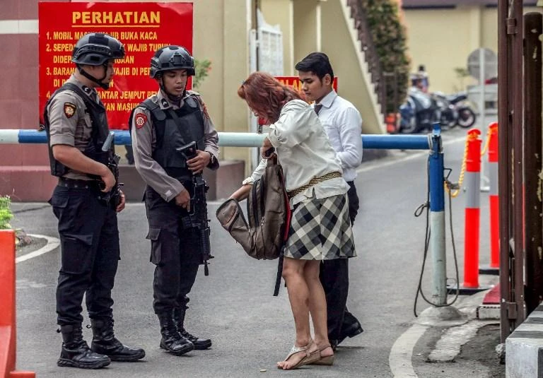 Armed Indonesian police perform an inspection as they keep watch at a security checkpoint in the wake of a deadly wave of suicide bombings in the country. (AFP)