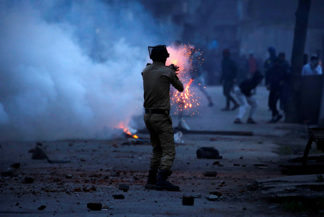 An Indian police officer fires a tear gas shell towards demonstrators, during a protest against the recent killings in Kashmir. (REUTERS/Danish Ismail TPX IMAGES OF THE DAY)