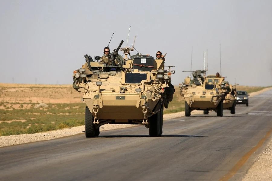 US troops sit atop an armoured vehicle on a road near the northern Syrian village of Ain Issa. (AFP)