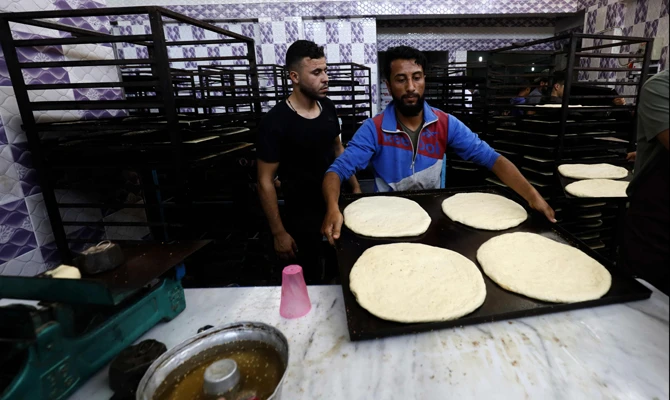 Artisans prepare sweet bread at a bakery in the Syrian city of Raqqa on Thursday, during the holy month of Ramadan. (AFP)
