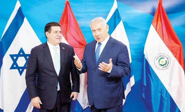 Israeli Prime Minister Benjamin Netanyahu gestures as he stands next to Paraguayan President Horacio Cartes at Netanyahu's office Monday. Reuters