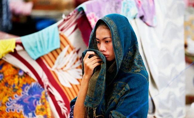 An evacuee stands inside her own section as hundreds of evacuees continue to be housed for almost five months now in a multi-purpose hall at Balo-i township, Lanao del Norte province after fleeing the besieged city of Marawi on Oct. 17, 2017 in southern Philippines. (AP)