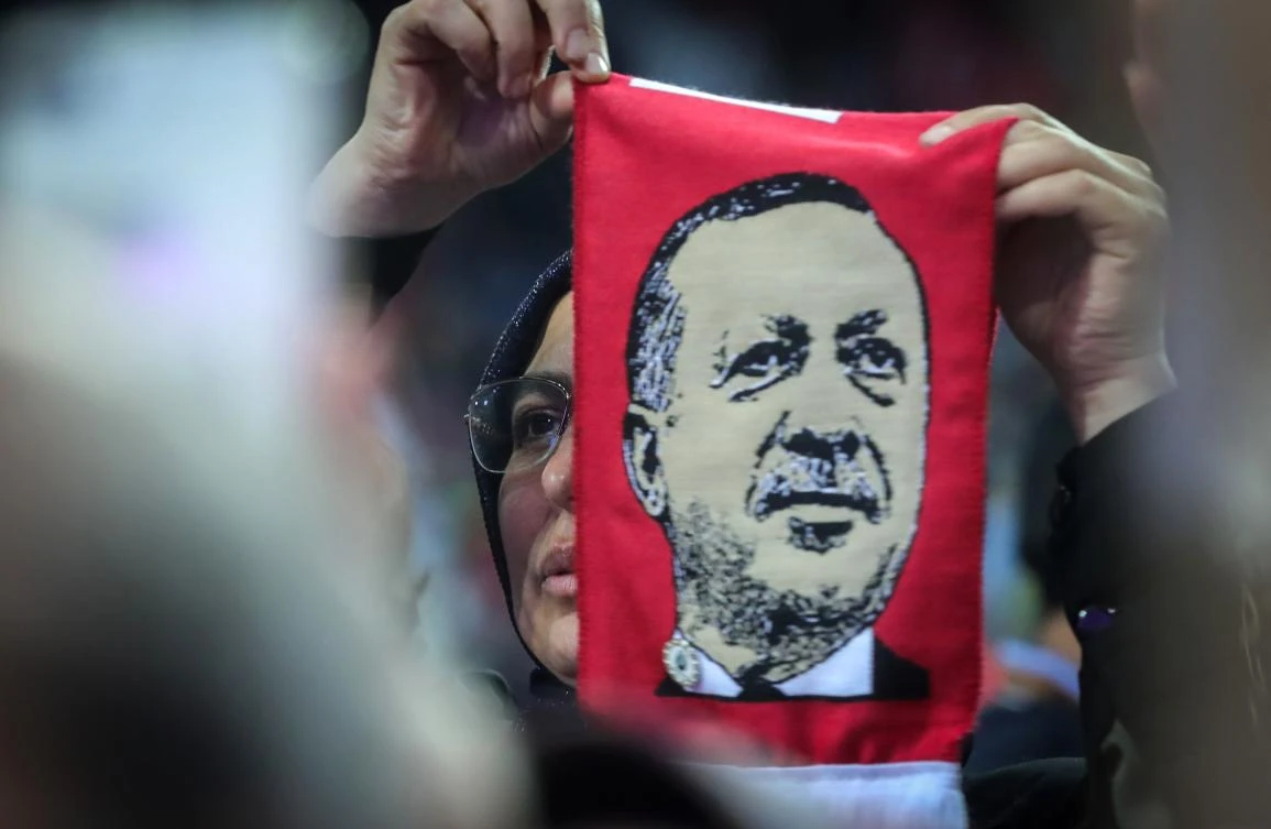 A supporter holds a scarf with an image of Turkish President Recep Tayyip Erdogan during a pre-election rally in Sarajevo, on May 20, 2018. (AFP)