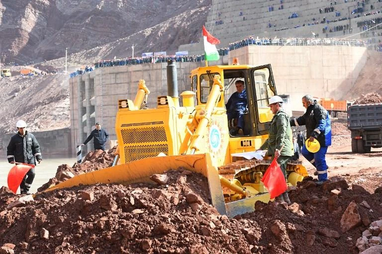 This handout picture released on October 29, 2016 by the Tajikistan President Press office shows Tajikistan's President Emomali Rakhmon (C) operating a bulldozer at the start of a construction ceremony of a controversial $4 billion Rogun hydroelectric dam. (AFP)