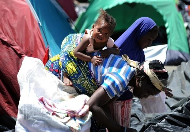 A migrant from Niger carries her child near a fruit market in the Algerian town of Boufarik. (AFP)