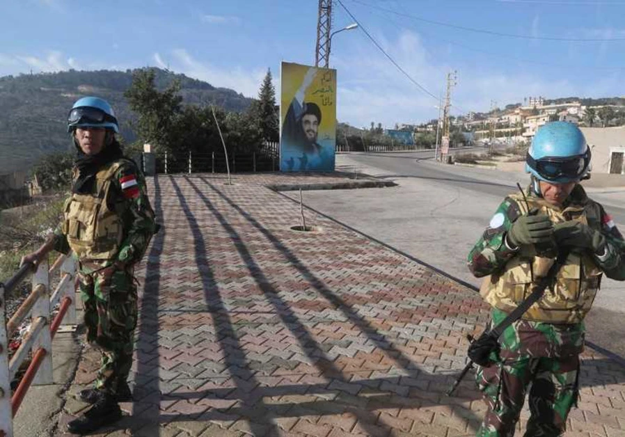 UNIFIL members beside a banner for Hezbollah leader Sayyed Hassan Nasrallah in south Lebanon. (Reuters)