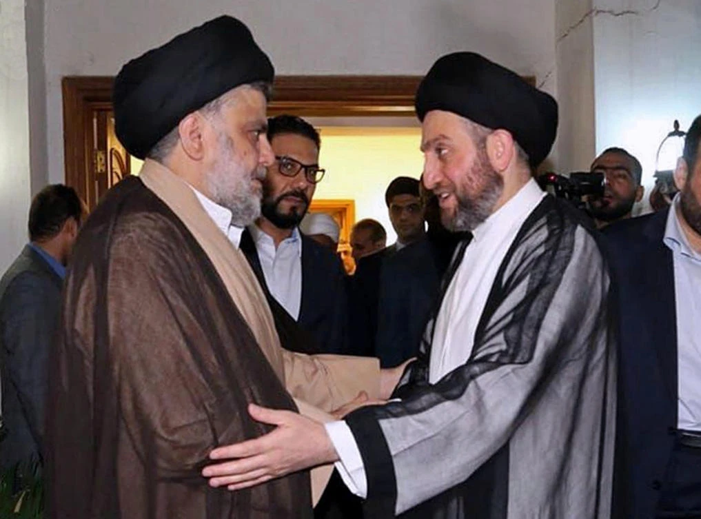 Muqtada Al-Sadr, left, greets Shiite leader Ammar Al-Hakim on his arrival for their meeting in Baghdad. (AP Photo)