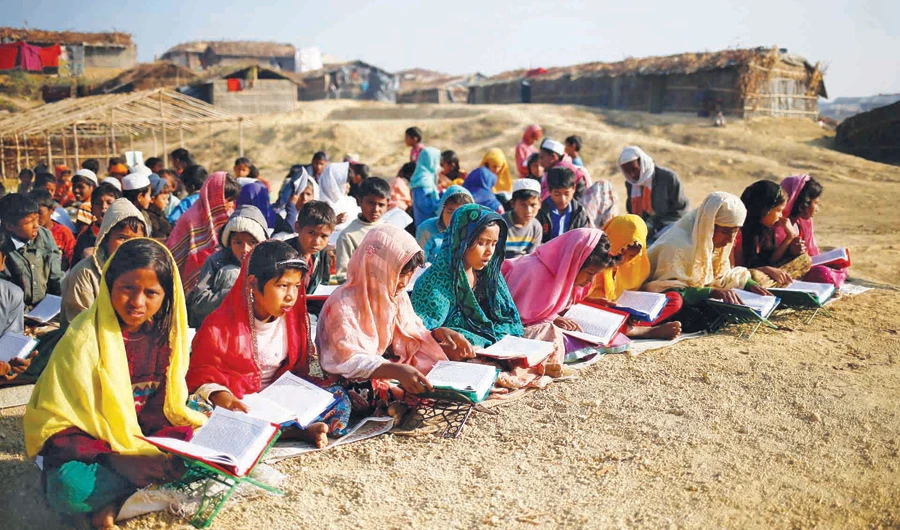 Children attending an open-air Arabic school in February at Kutupalong refugee camp, where they were learning to read the Qur’an. (Reuters)