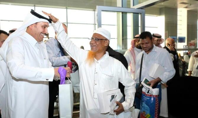 Director General of Saudi Arabian Airlines, Saleh bin Nasser Al-Jasser, greets a passenger at the Jeddah airport.