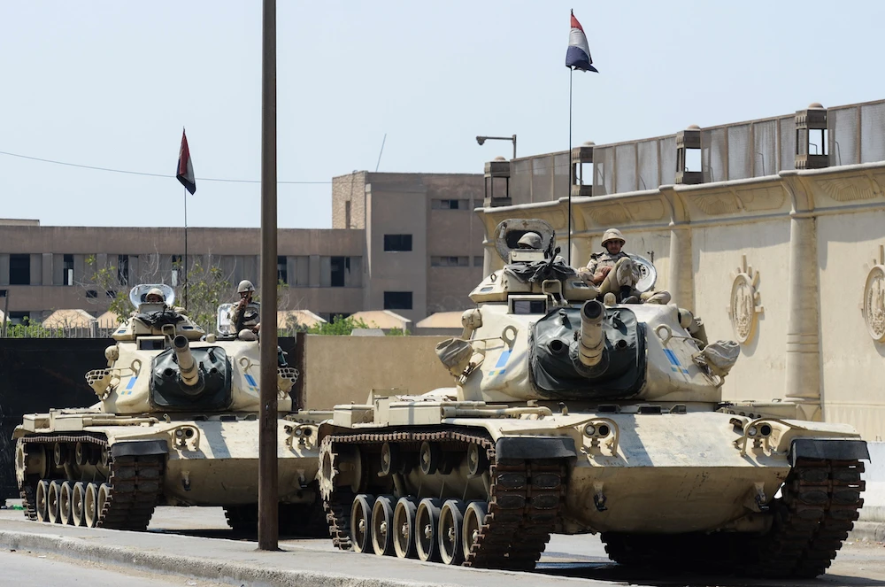 Egyptian military tanks are positioned outside the police institute near Cairo's Turah prison during the trial of three detained journalists with the Qatar-based Al-Jazeera broadcaster on April 10, 2014. (AFP PHOTO / MOHAMED EL-SHAHED / AFP PHOTO / MOHAMED EL-SHAHED)