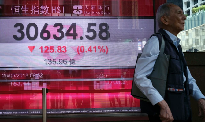 A man walks past a bank electronic board showing the Hong Kong share index at Hong Kong Stock Exchange Friday. (AP Photo/Vincent Yu)