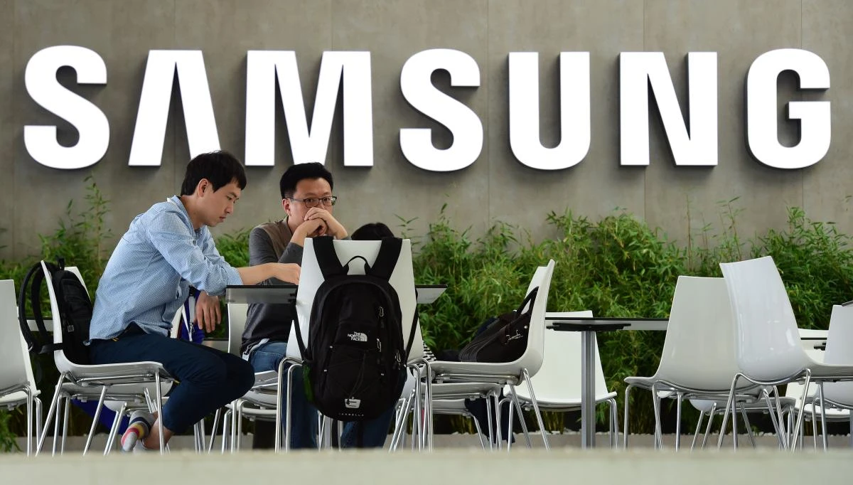 In this file photo taken on September 02, 2015 people sit in front the logo of South Korean electronics giant Samsung ahead of the opening of the 55th IFA (Internationale Funkausstellung) in Berlin. (AFP)