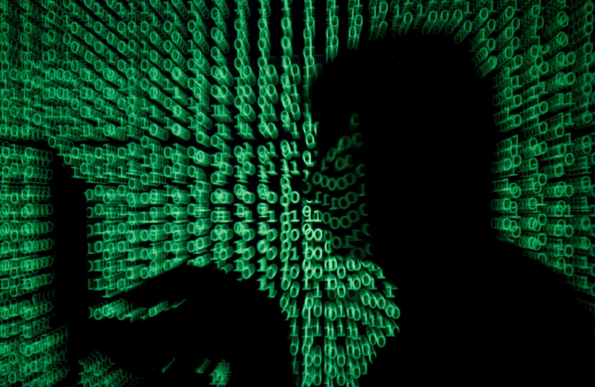 File photo showing a man holds a laptop computer as cyber code is projected on him in this illustration picture taken, May 13, 2017. (Reuters)