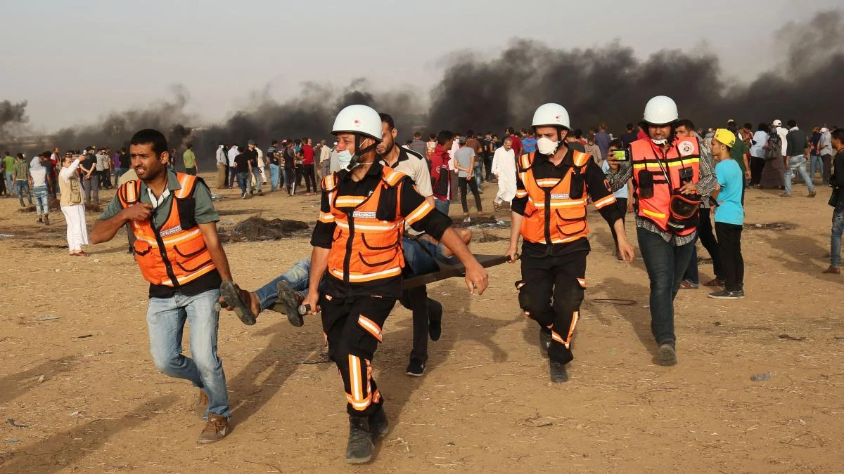 Palestinian paramedics carry away a protester injured during a demonstration along the border between Israel and the Gaza strip, east of Khan Yunis. (AFP)