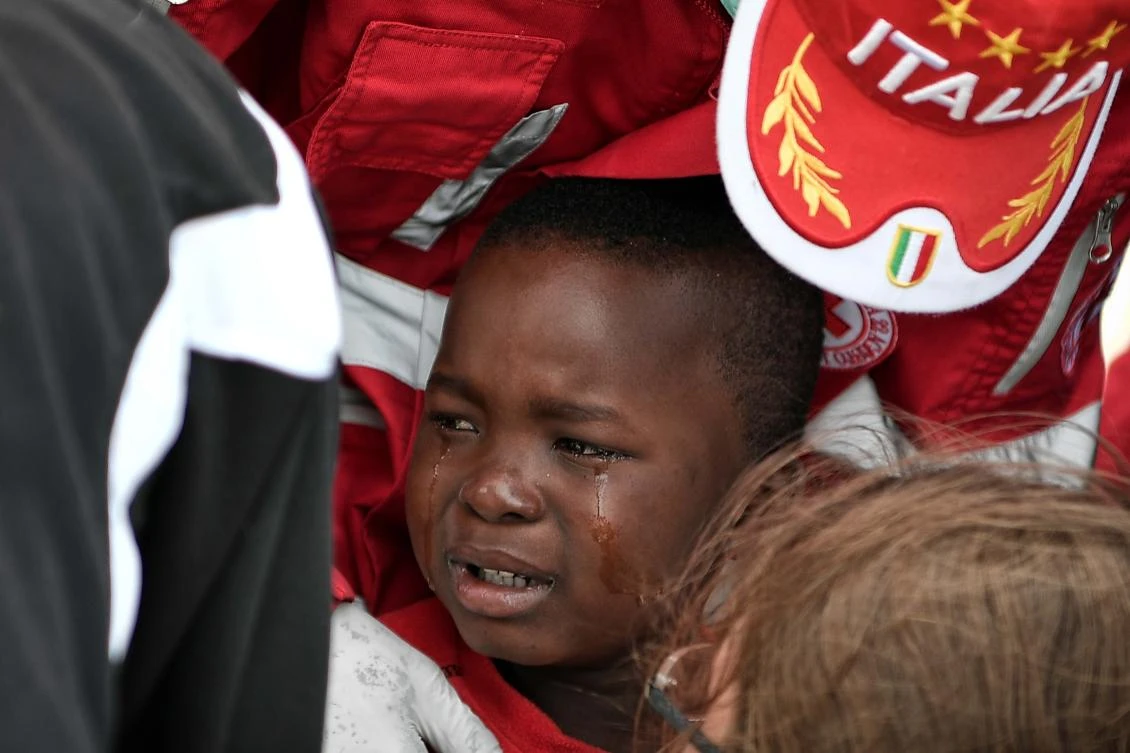 A migrant child is tearful after disembarking from the MV Aquarius at the Sicilian port of Messina on May 14, 2018. (AFP)