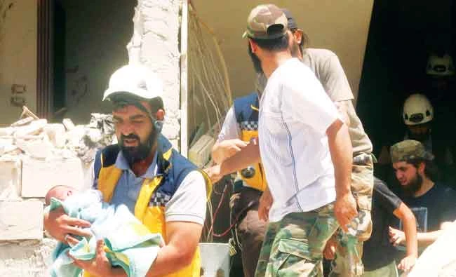 Syrian civil defense members conduct search and rescue operations and rescue a baby after an explosion was carried out with a bomb-laden vehicle in Idlib, on Saturday. Getty Images