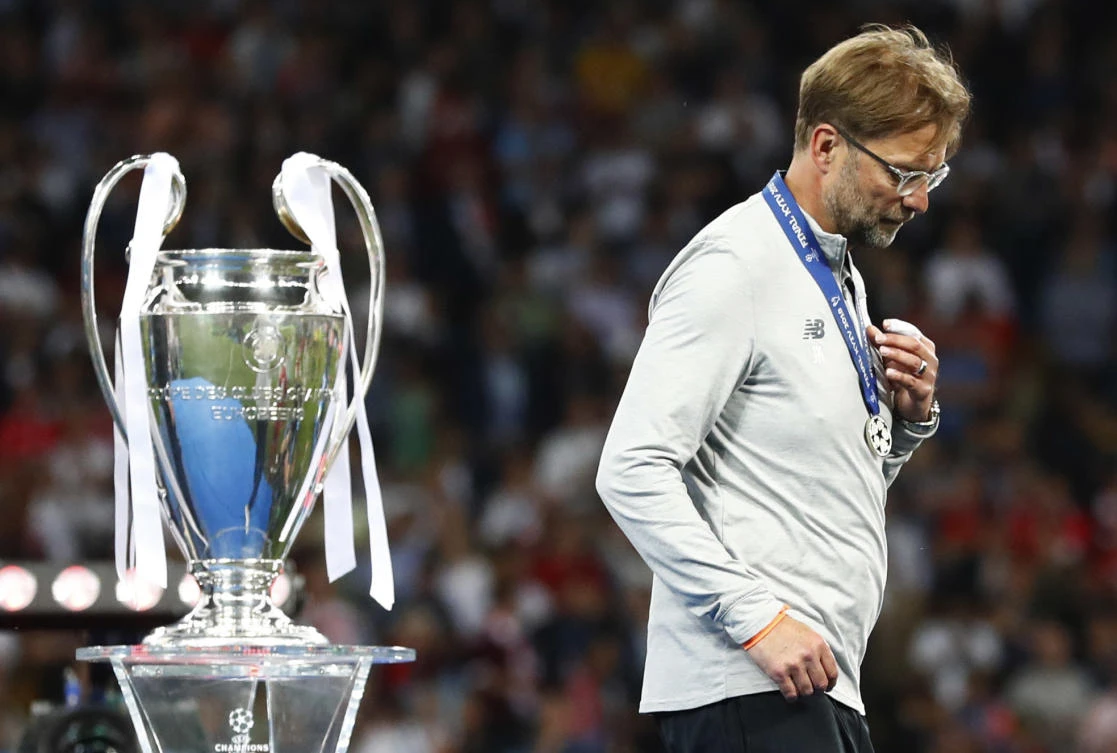 Liverpool coach Jurgen Klopp walks past the trophy at the end of the Champions League Final soccer match between Real Madrid and Liverpool at the Olimpiyskiy Stadium in Kiev, Ukraine, Saturday, May 26, 2018. (AP Photo/Matthias Schrader)