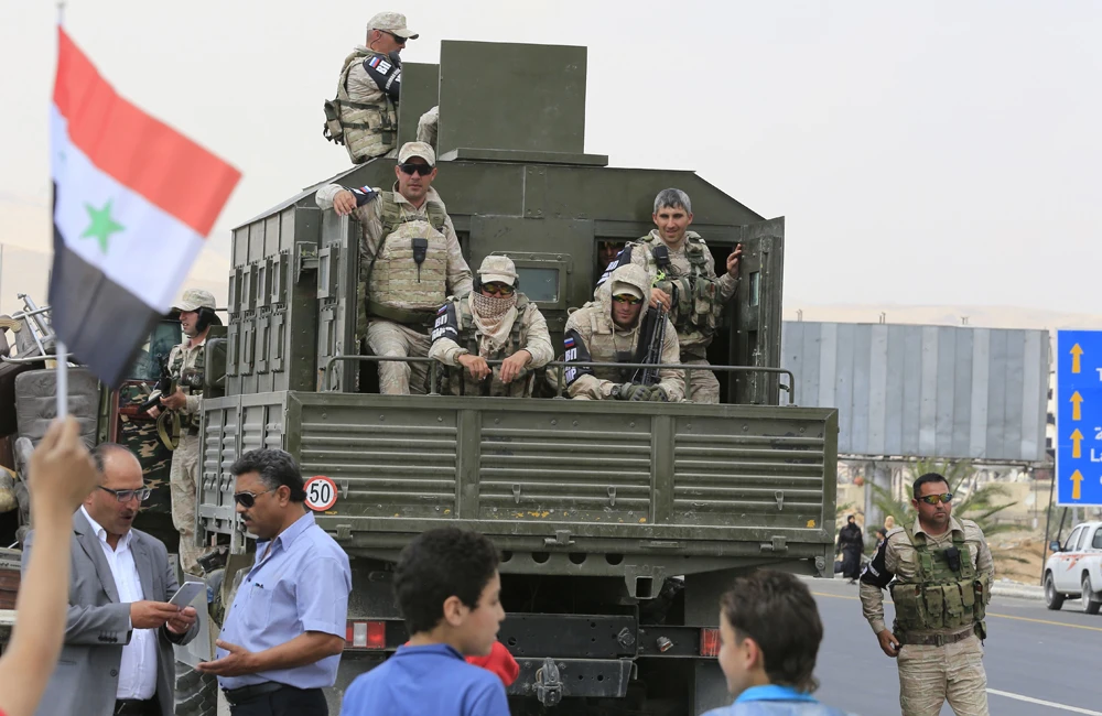 A military vehicle carrying members of the Russian Military Police is parked on the highway extending from Harasta in Eastern Ghouta on the outskirts of Damascus to the northern part of Syria, after it reopened to traffic on May 15, 2018. (AFP / LOUAI BESHARA)