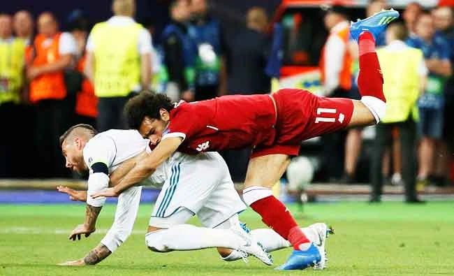 Liverpool's Mohamed Salah injures his shoulder in a challenge with Real Madrid's Sergio Ramos. (REUTERS)
