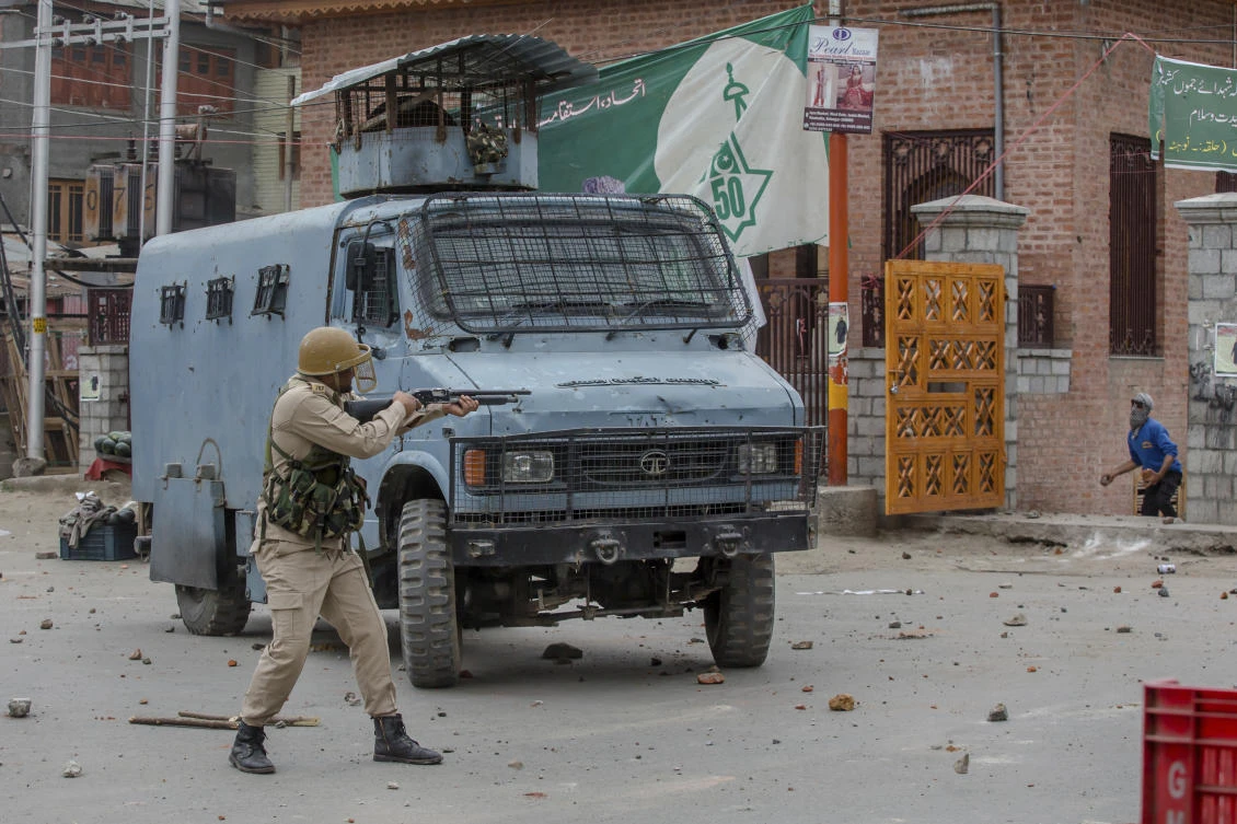 An Indian policeman fires a pellet gun at Kashmiri protesters in Srinagar, Indian controlled Kashmir, Friday, May 18, 2018. (AP)
