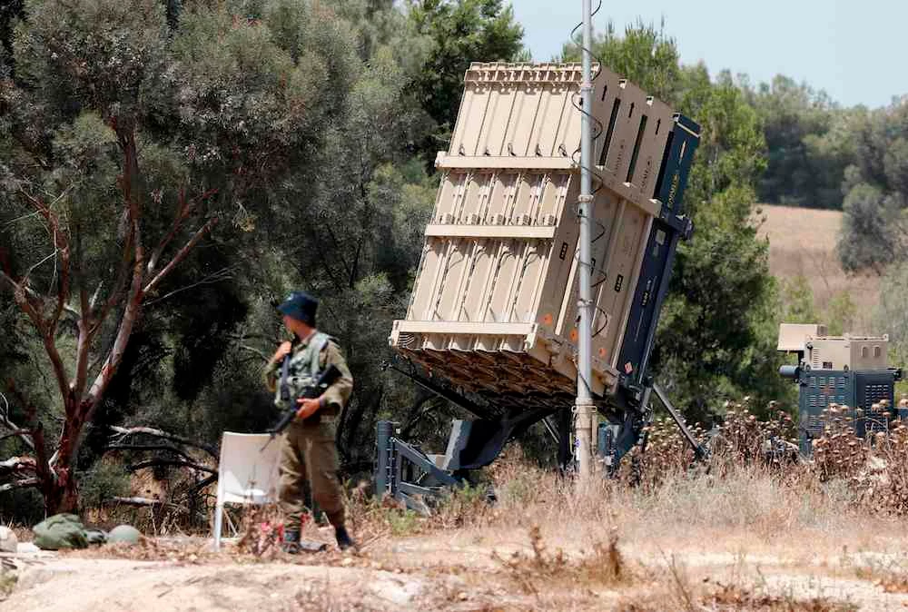 Photo showing Israeli soldiers stand guard next to an Israeli Iron Dome defence system, designed to intercept and destroy incoming short-range rockets and artillery shells, deployed along the border with the Gaza strip, May 29, 2018. (AFP)