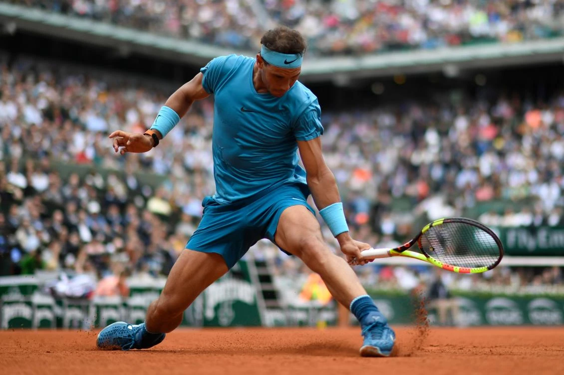 Spain's Rafael Nadal slides to play a backhand return during his first-round match. (AFP)